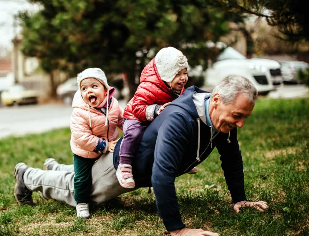 Grossvater mit Kindern auf Rücken 